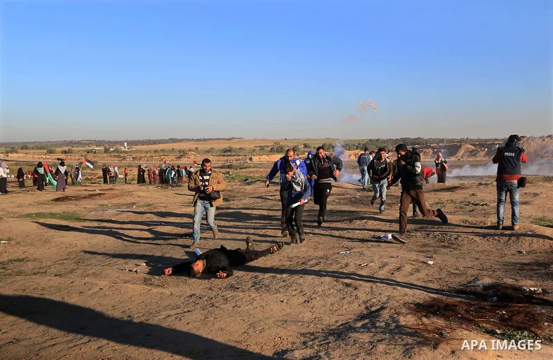 Palestinian protesters gather during clashes with Israeli troops in tents protest where Palestinians demand the right to return to their homeland at the Israel-Gaza border, in al-Bureij in the center of Gaza Strip on Dec...