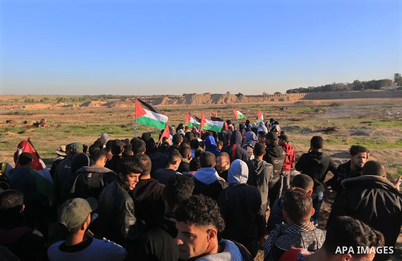 Palestinian protesters gather during clashes with Israeli troops in tents protest where Palestinians demand the right to return to their homeland at the Israel-Gaza border, in al-Bureij in the center of Gaza Strip on Dec...