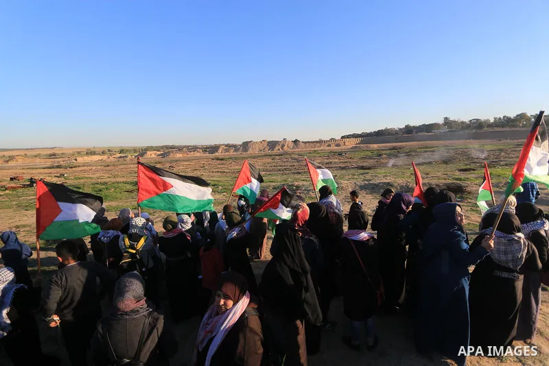 Palestinian protesters gather during clashes with Israeli troops in tents protest where Palestinians demand the right to return to their homeland at the Israel-Gaza border, in al-Bureij in the center of Gaza Strip on Dec...