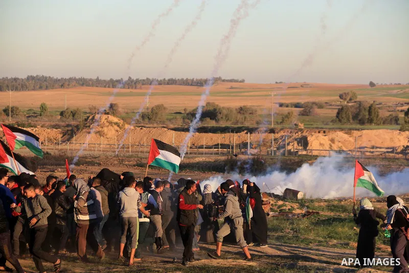 Palestinian protesters gather during clashes with Israeli troops in tents protest where Palestinians demand the right to return to their homeland at the Israel-Gaza border, in al-Bureij in the center of Gaza Strip on Dec...