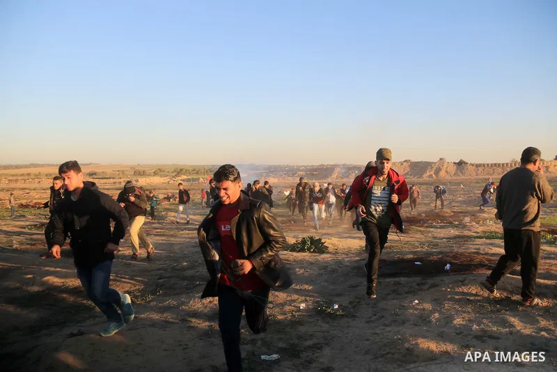 Palestinian protesters gather during clashes with Israeli troops in tents protest where Palestinians demand the right to return to their homeland at the Israel-Gaza border, in al-Bureij in the center of Gaza Strip on Dec...