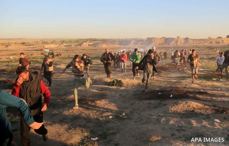 Palestinian protesters gather during clashes with Israeli troops in tents protest where Palestinians demand the right to return to their homeland at the Israel-Gaza border, in al-Bureij in the center of Gaza Strip on Dec...