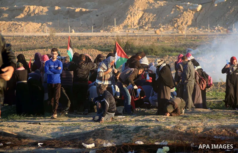 Palestinian protesters gather during clashes with Israeli troops in tents protest where Palestinians demand the right to return to their homeland at the Israel-Gaza border, in al-Bureij in the center of Gaza Strip on Dec...