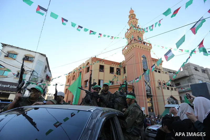 Palestinian members of al-Qassam Brigades, the armed wing of the Hamas movement, display their weapons during a military parade marking the 31th anniversary of Hamas' finding, in Khan Yunis City, southern Gaza strip, Dec...