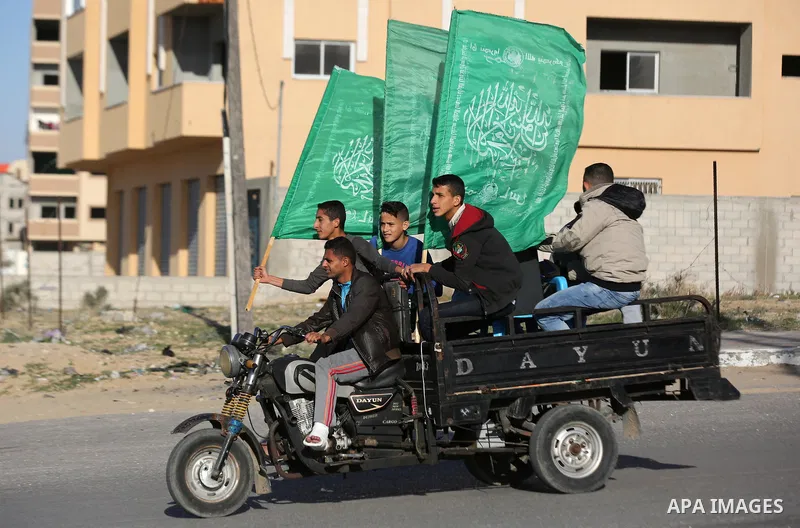 Palestinian members of al-Qassam Brigades, the armed wing of the Hamas movement, display their weapons during a military parade marking the 31th anniversary of Hamas' finding, in Khan Yunis City, southern Gaza strip, Dec...