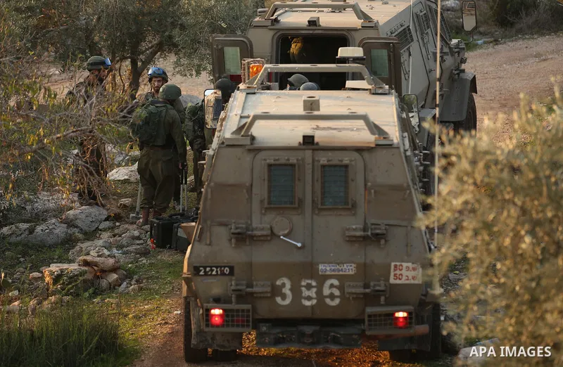 Israeli soldiers take position as an excavator destroys the house of Palestinian man Ashraf Naalwa in the village of Shuwaykah, near the West Bank city of Tulkarem, on December 17, 2018. Ashraf Naalwa was killed on Decem...