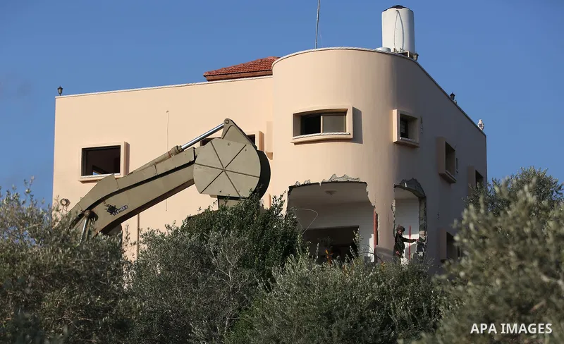 An excavator of the Israeli forces destroys the house of Palestinian man Ashraf Naalwa in the village of Shuwaykah, near the West Bank city of Tulkarem, on December 17, 2018. - Ashraf Naalwa was killed on December 12 by...