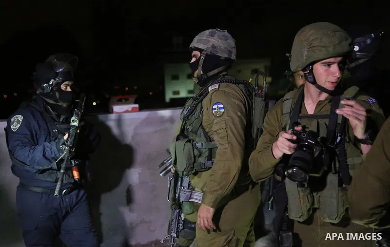 Israeli soldiers take position as an excavator destroys the house of Palestinian man Ashraf Naalwa in the village of Shuwaykah, near the West Bank city of Tulkarem, on December 17, 2018. Ashraf Naalwa was killed on Decem...