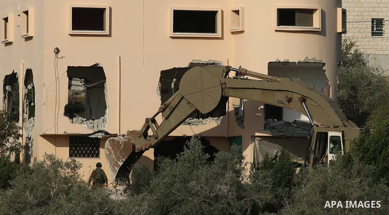 An excavator of the Israeli forces destroys the house of Palestinian man Ashraf Naalwa in the village of Shuwaykah, near the West Bank city of Tulkarem, on December 17, 2018. - Ashraf Naalwa was killed on December 12 by...