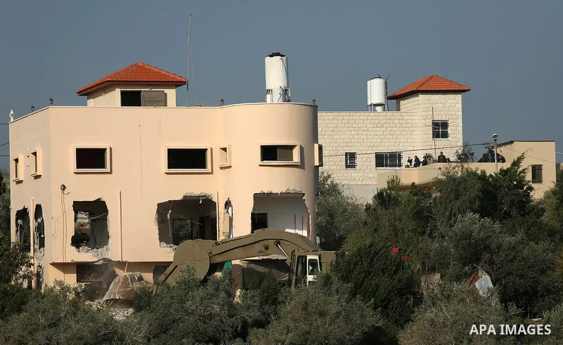 An excavator of the Israeli forces destroys the house of Palestinian man Ashraf Naalwa in the village of Shuwaykah, near the West Bank city of Tulkarem, on December 17, 2018. - Ashraf Naalwa was killed on December 12 by...