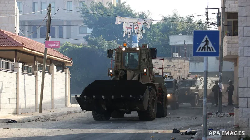 Israeli soldiers take position as an excavator destroys the house of Palestinian man Ashraf Naalwa in the village of Shuwaykah, near the West Bank city of Tulkarem, on December 17, 2018. Ashraf Naalwa was killed on Decem...