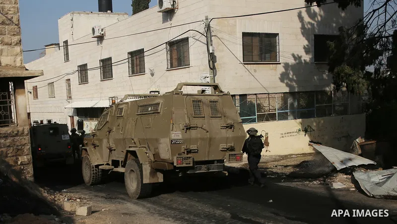 Israeli soldiers take position as an excavator destroys the house of Palestinian man Ashraf Naalwa in the village of Shuwaykah, near the West Bank city of Tulkarem, on December 17, 2018. Ashraf Naalwa was killed on Decem...