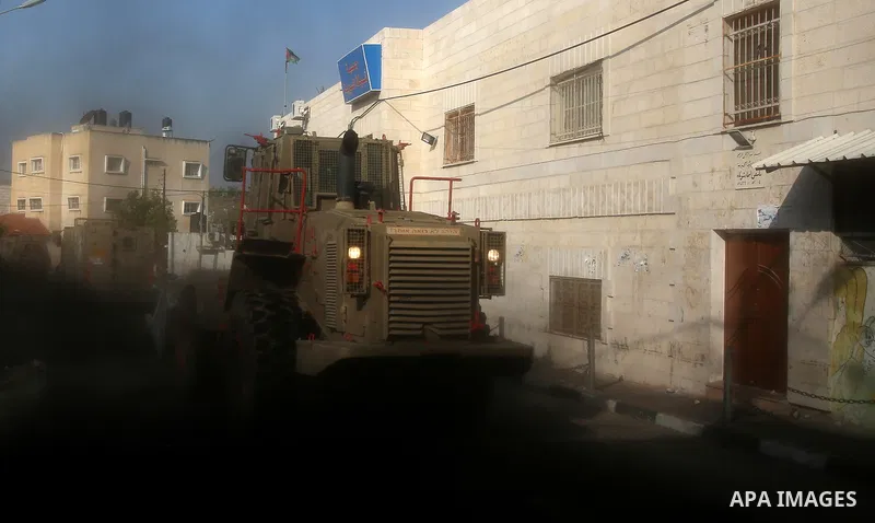 Israeli soldiers take position as an excavator destroys the house of Palestinian man Ashraf Naalwa in the village of Shuwaykah, near the West Bank city of Tulkarem, on December 17, 2018. Ashraf Naalwa was killed on Decem...