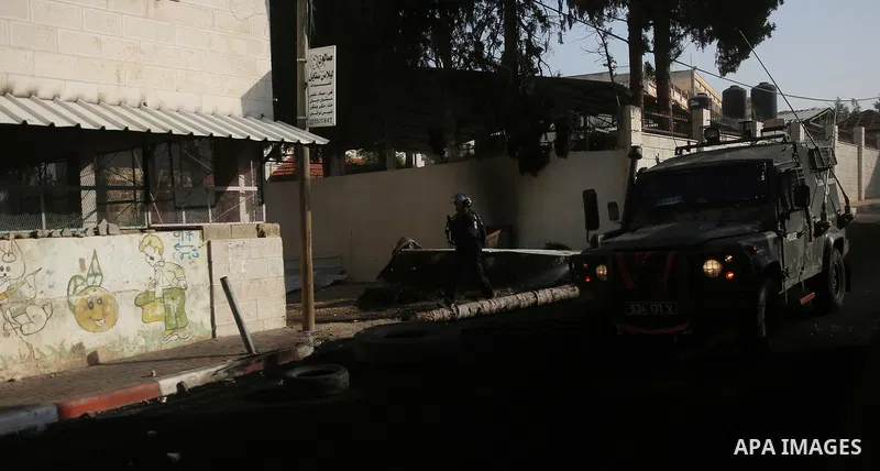 Israeli soldiers take position as an excavator destroys the house of Palestinian man Ashraf Naalwa in the village of Shuwaykah, near the West Bank city of Tulkarem, on December 17, 2018. Ashraf Naalwa was killed on Decem...