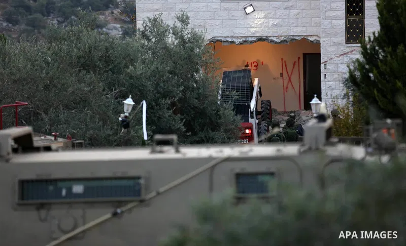Israeli soldiers take position as an excavator destroys the house of Palestinian man Ashraf Naalwa in the village of Shuwaykah, near the West Bank city of Tulkarem, on December 17, 2018. Ashraf Naalwa was killed on Decem...