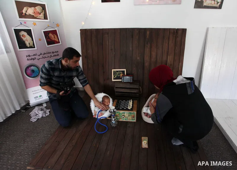 Yahya Barzaq, 28, a Palestinian photographer prepares a new born baby for a photograph during a photo session at his studio in Gaza city, December 17, 2018. Photo by Mahmoud Ajjour