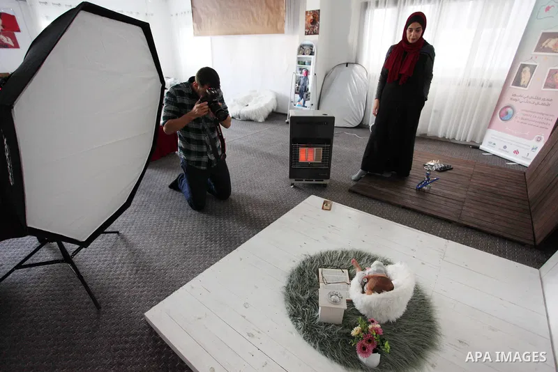 Yahya Barzaq, 28, a Palestinian photographer takes a photo during a new born baby photo session at his studio in Gaza city, December 17, 2018. Photo by Mahmoud Ajjour