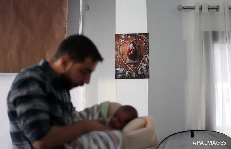 Yahya Barzaq, 28, a Palestinian photographer prepares a new born baby for a photograph during a photo session at his studio in Gaza city, December 17, 2018. Photo by Mahmoud Ajjour