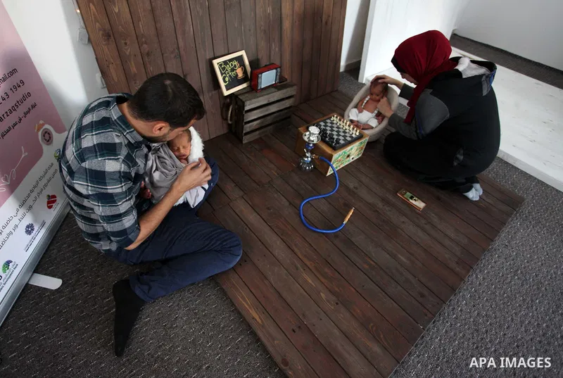 Yahya Barzaq, 28, a Palestinian photographer prepares a new born baby for a photograph during a photo session at his studio in Gaza city, December 17, 2018. Photo by Mahmoud Ajjour