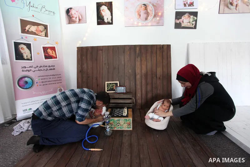Yahya Barzaq, 28, a Palestinian photographer prepares a new born baby for a photograph during a photo session at his studio in Gaza city, December 17, 2018. Photo by Mahmoud Ajjour