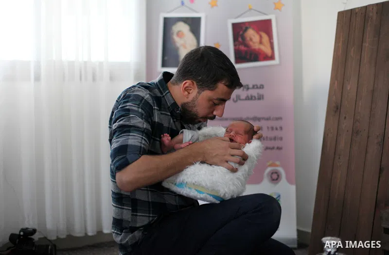Yahya Barzaq, 28, a Palestinian photographer prepares a new born baby for a photograph during a photo session at his studio in Gaza city, December 17, 2018. Photo by Mahmoud Ajjour