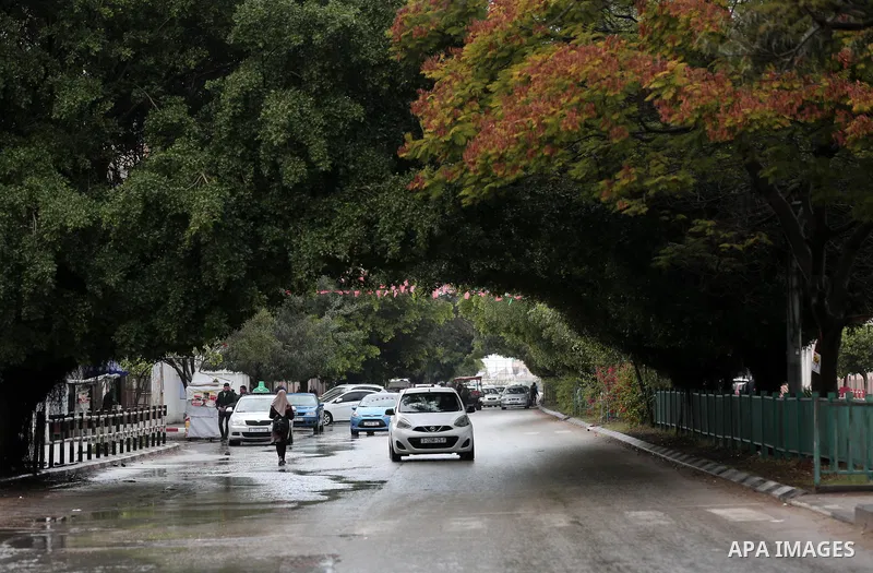Palestinians walk in a flooded street during a rainy day in Gaza city on December 20, 2018. Photo by Ashraf Amra