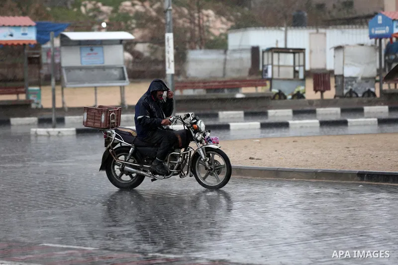 A Palestinian man rides a motorcycle during a rainy day in Gaza city on December 20, 2018. Photo by Ashraf Amra