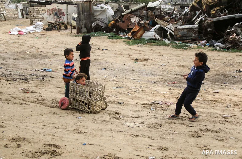 A picture taken on December 20, 2018 shows Palestinian children play outside their family's dwelling during winter season at Nahr al-Bared refugee camp in Khan Younis in the southern Gaza Strip. Photo by Mahmoud Khattab