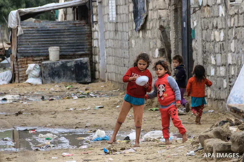 A picture taken on December 20, 2018 shows Palestinian children play outside their family's dwelling during winter season at Nahr al-Bared refugee camp in Khan Younis in the southern Gaza Strip. Photo by Mahmoud Khattab