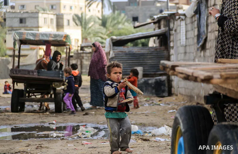 A picture taken on December 20, 2018 shows Palestinian children play outside their family's dwelling during winter season at Nahr al-Bared refugee camp in Khan Younis in the southern Gaza Strip. Photo by Mahmoud Khattab