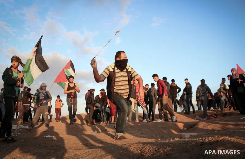 Palestinian protesters gather during clashes with Israeli troops in tents protest where Palestinians demand the right to return to their homeland at the Israel-Gaza border, in east of Gaza City on December 21, 2018. Phot...