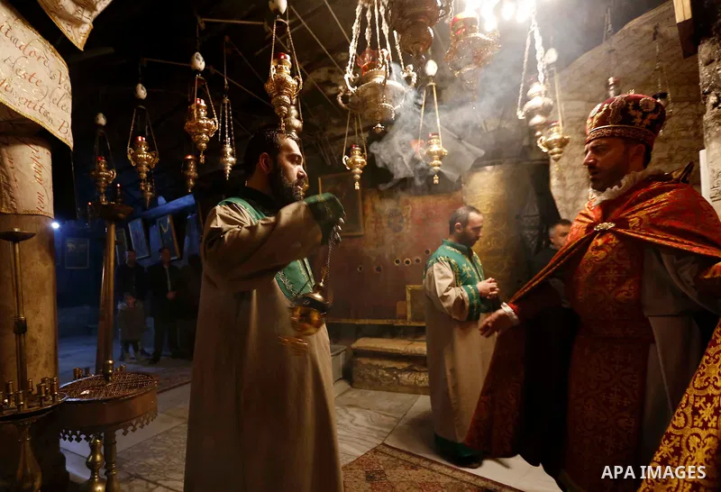 Christian worshippers pray inside the Grotto, believed to be the exact spot where Jesus Christ was born, at the Church of the Nativity in the biblical West Bank city of Bethlehem, a head of the Christmas celebrations on...