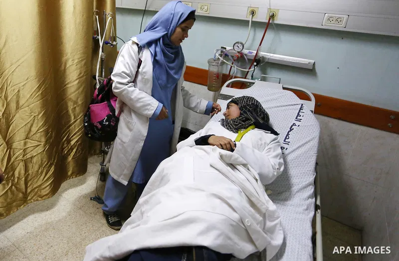 A Palestinian paramedic who was wounded during clashes between Palestinian protesters and Israeli troops on Israel-Gaza border, receives treatment at a hospital in Khan Younis in the southern Gaza Strip on December 28, 2...