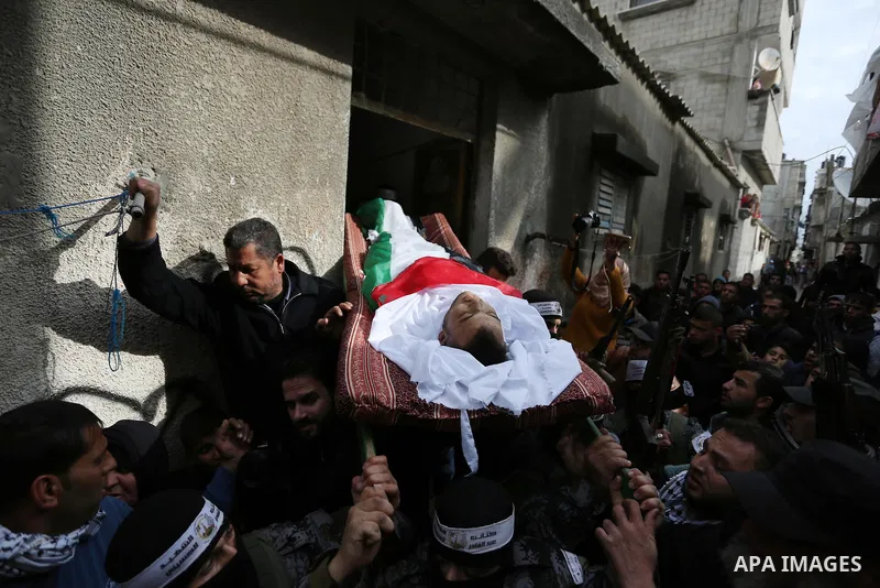 Mourners carry the body of Palestinian Karam Fayyad, 26, who was shot dead by Israeli troops during clashes on Israel-Gaza border, during his funeral in Khan Younis in the southern Gaza Strip on December 29, 2018. Photo...