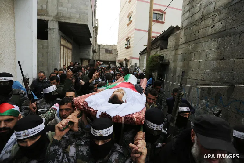 Mourners carry the body of Palestinian Karam Fayyad, 26, who was shot dead by Israeli troops during clashes on Israel-Gaza border, during his funeral in Khan Younis in the southern Gaza Strip on December 29, 2018. Photo...