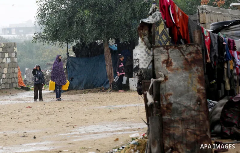 Palestinian children play outside their family's dwelling during a rainy day at Nahr al-Bared refugee camp in Khan Younis in the southern Gaza Strip on December 30, 2018. Photo by Ashraf Amra