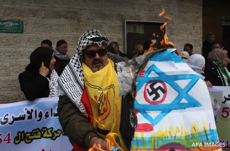 Palestinians burn an Israeli, British and U.S. flags during a protest to show solidarity with Palestinian prisoners held in Israeli jails, in front of Red cross office in Gaza city, on December 31, 2018. Photo by Mahmoud...