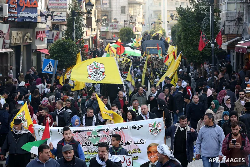 Palestinians take part during a rally marking the 54th anniversary of Fatah's founding, in the West Bank city of Ramallah, on December 31, 2018. Photo by Ahmad Arouri