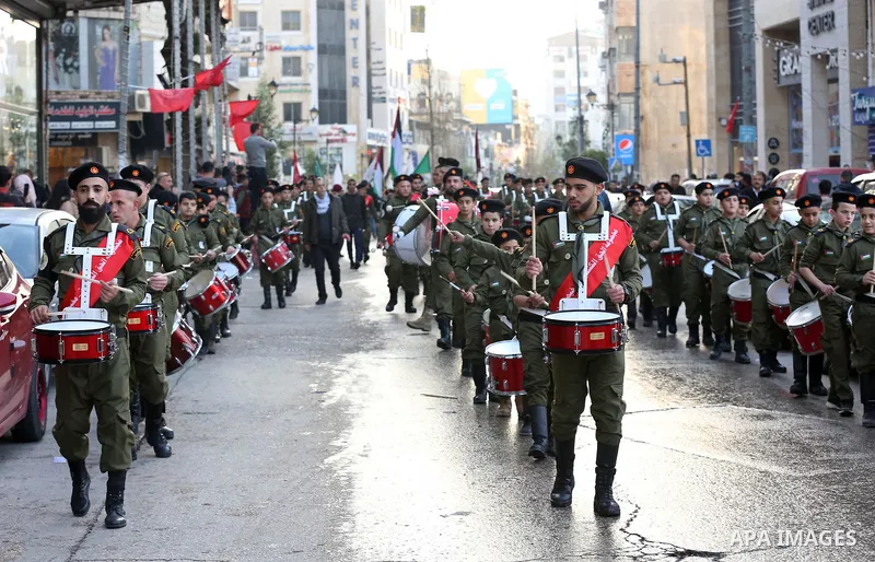 Palestinian scouts perform during a rally marking the 54th anniversary of Fatah's founding, in the West Bank city of Ramallah, on December 31, 2018. Photo by Ahmad Arouri