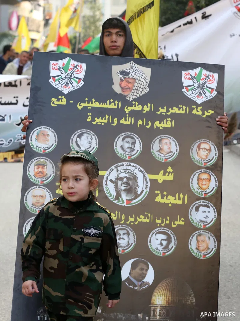 Palestinians take part during a rally marking the 54th anniversary of Fatah's founding, in the West Bank city of Ramallah, on December 31, 2018. Photo by Ahmad Arouri
