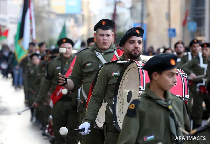 Palestinian scouts perform during a rally marking the 54th anniversary of Fatah's founding, in the West Bank city of Ramallah, on December 31, 2018. Photo by Ahmad Arouri