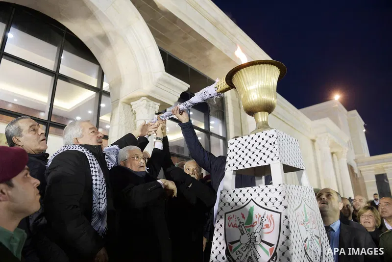 Palestinian President Mahmoud Abbas light a torch during a ceremony marking the 54th anniversary of Fatah's founding, in the West Bank city of Ramallah, on December 31, 2018. Photo by Thaer Ganaim