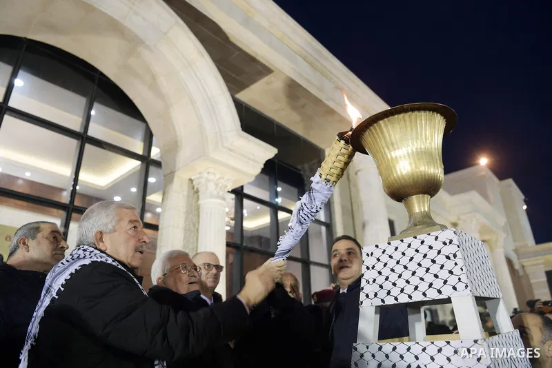 Palestinian President Mahmoud Abbas light a torch during a ceremony marking the 54th anniversary of Fatah's founding, in the West Bank city of Ramallah, on December 31, 2018. Photo by Thaer Ganaim