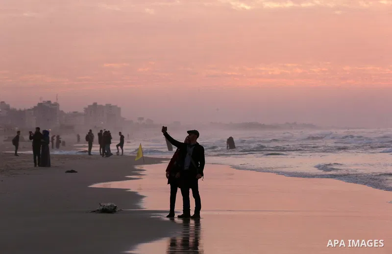 Palestinians enjoy their time on the beach during sunset in the last day of 2018, a few hours prior to the new year's celebrations, in Gaza city on December 31, 2018. Photo by Ashraf Amra