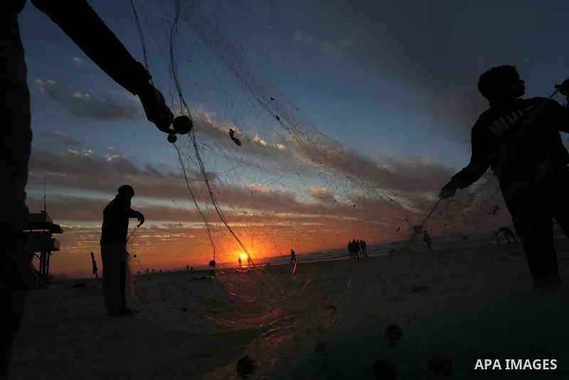 Palestinian fishermen work on the beach during sunset in the last day of 2018, a few hours prior to the new year's celebrations, in Gaza city on December 31, 2018. Photo by Ashraf Amra