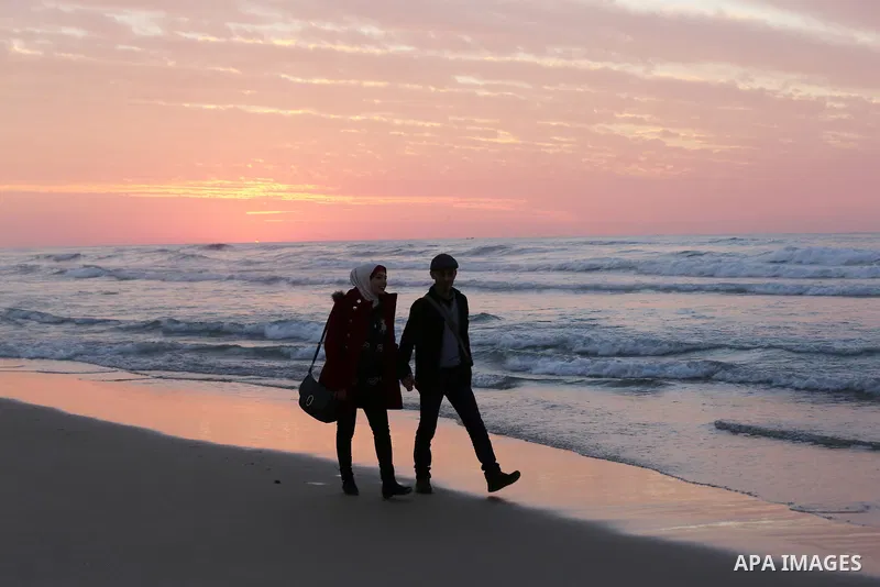 Palestinians enjoy their time on the beach during sunset in the last day of 2018, a few hours prior to the new year's celebrations, in Gaza city on December 31, 2018. Photo by Ashraf Amra