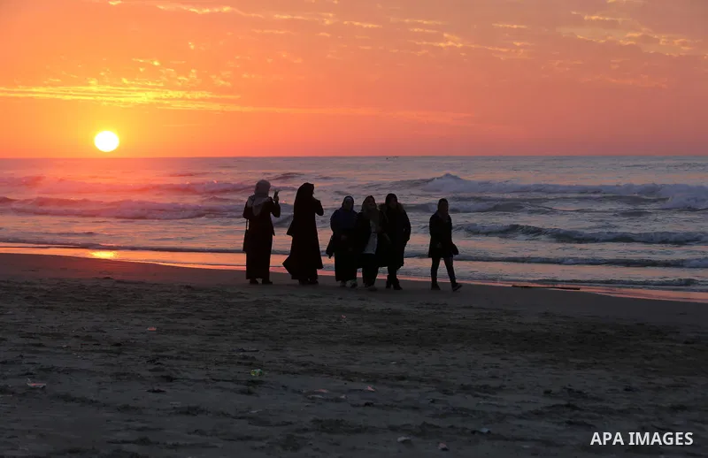 Palestinians enjoy their time on the beach during sunset in the last day of 2018, a few hours prior to the new year's celebrations, in Gaza city on December 31, 2018. Photo by Ashraf Amra