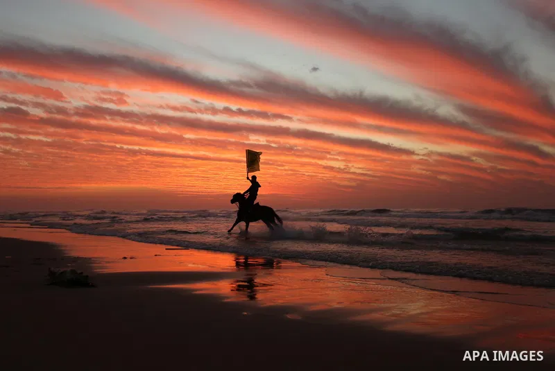 Palestinians enjoy their time on the beach during sunset in the last day of 2018, a few hours prior to the new year's celebrations, in Gaza city on December 31, 2018. Photo by Ashraf Amra