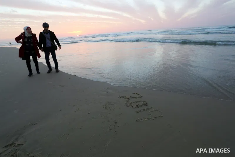 Palestinians enjoy their time on the beach during sunset in the last day of 2018, a few hours prior to the new year's celebrations, in Gaza city on December 31, 2018. Photo by Ashraf Amra