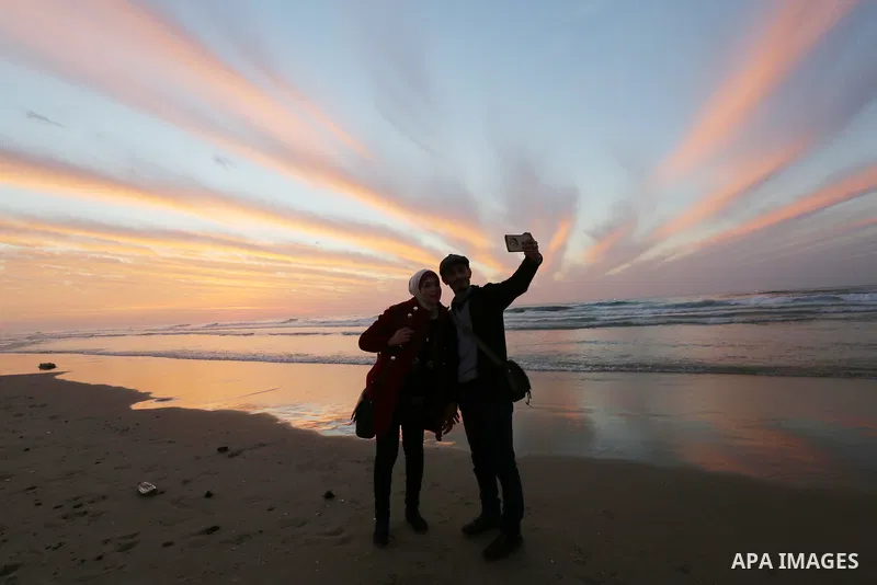 Palestinians enjoy their time on the beach during sunset in the last day of 2018, a few hours prior to the new year's celebrations, in Gaza city on December 31, 2018. Photo by Ashraf Amra